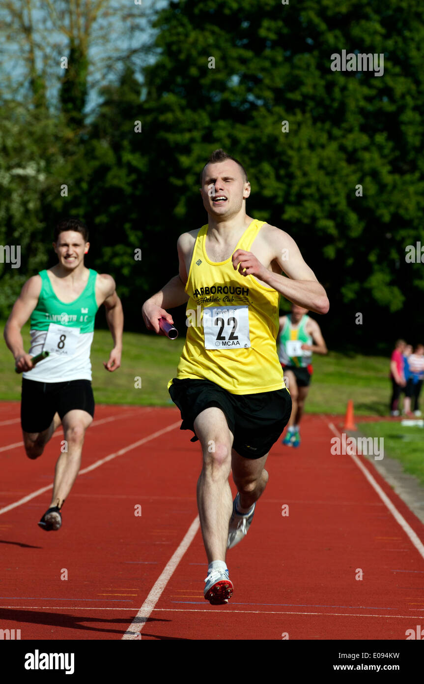Athletics, runner finishing in men`s 4X400m relay race at club level, UK Stock Photo